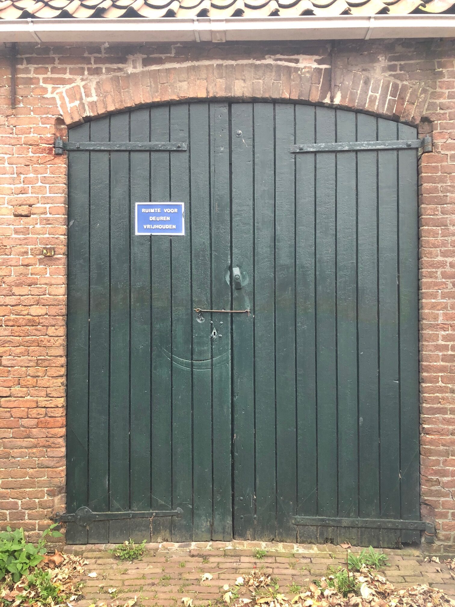 twee groene deuren met daarop een bordje ruimte voor deuren vrijhouden